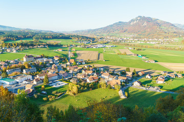 Fototapeta na wymiar Aerial view of a beautiful landscape with traditional houses, green meadows, Gruyeres, Switzerland