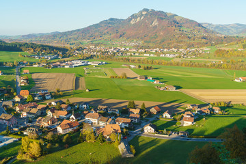 Fototapeta na wymiar Aerial view of a beautiful landscape with traditional houses, green meadows, Gruyeres, Switzerland
