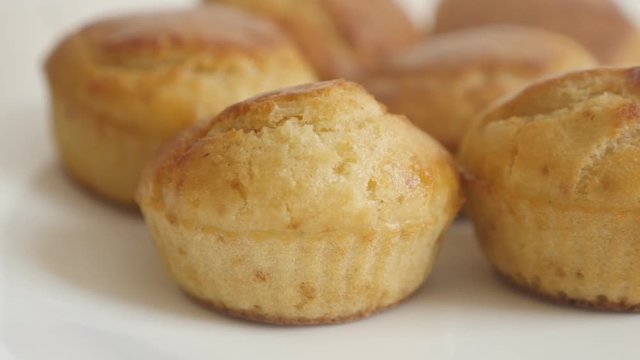 Close-up muffin shaped cornbread pile slow tilt footage - Tasty cornmeal on white plate
