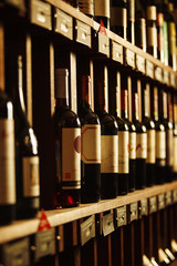 Wine cellar with elite drinks on shelves with written names