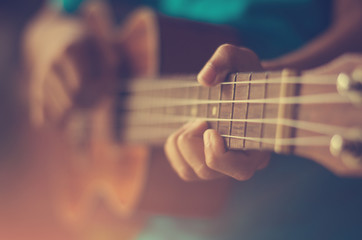 Hands playing acoustic guitar ukulele  - obrazy, fototapety, plakaty