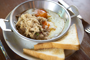 Egg pan breakfast with bread ont he table.