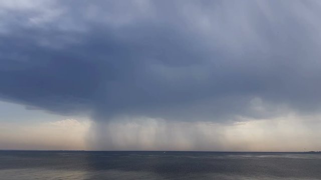 Rain over river. Beautiful thunder clouds over the river, shooting from a car that goes on the road along the water. Insects and birds fly, Day, Dynamic scene, 4k video