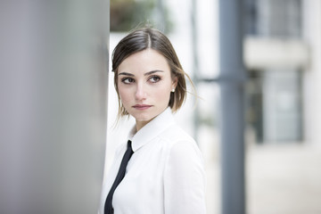 ritratto di un manager donna con camicia bianca e cravatta in un contesto aziendale in esterni