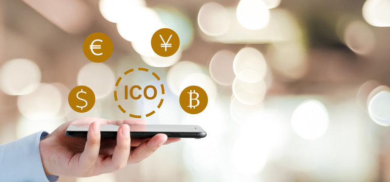 Businessman hand using smartphone with ICO, Initial Coin Offering, icon on a virtual screen. Cryptocurrency, Bitcoin and ICO Digital Electronic Trade Market Stock Index concept.