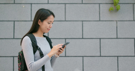 Asian woman reading on smart phone at outdoor