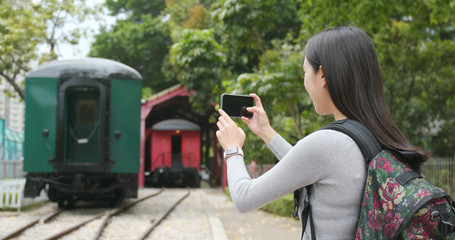 Tourist travel and taking phone on cellphone at train station