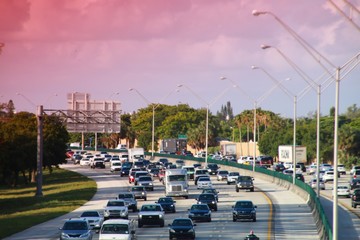 Traffic moves steadily along I-95 north and south in a hot sunny morning in rush hour through long...