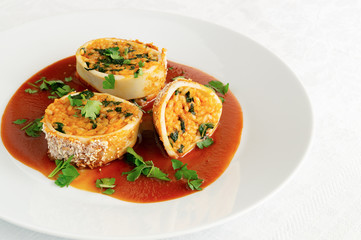 roasted breaded calamari stuffed with rice and spinach in tomato sauce decorated with parsley