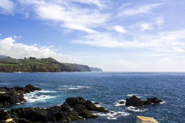 Coastline landscape with Blue Ocean and land with green fields 