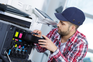 young man fixing printer
