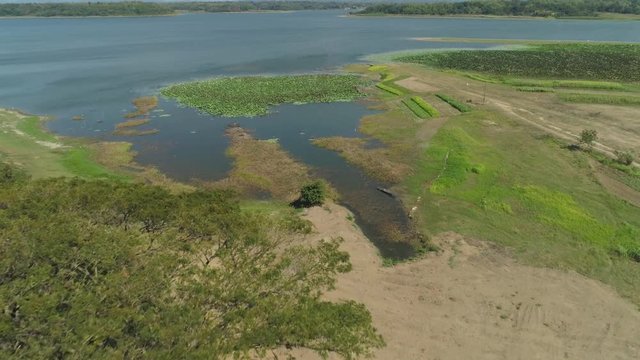 Aerial view of Paoay Lake with water lilies, Philippines. Lake against background of mountains and sky with clouds. Paoay Lake National Park, Ilocos Norte.