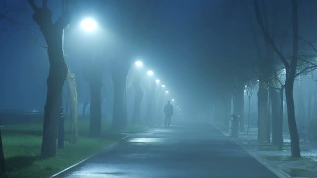 man walking in stormy and foggy weather
