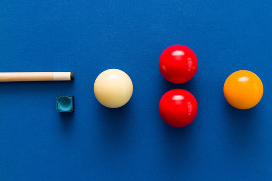 Balls and a cue seen on the table of a Carom Billiard
