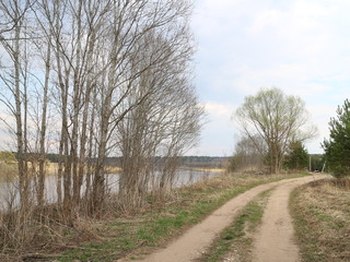 Fototapeta na wymiar country road along the river in the spring