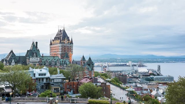 Timelapse, time lapse in 4k of cityscape or skyline of Chateau Frontenac castle, park and old town streets in Quebec City, Canada during sunset with people walking on Dufferin Terrace