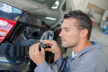 Mechanic looking at cables for car indicator