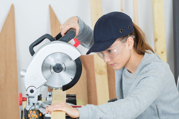 female carpenter is using a circular saw