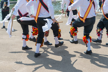 Morris Men wearing bells and white shirts and stockings dance on May Day Bank Holiday with sticks...