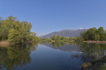 Fototapeta na wymiar Grande lago con montagne e riflesso sull'acqua