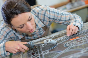 Female artist applying lead to glass - obrazy, fototapety, plakaty