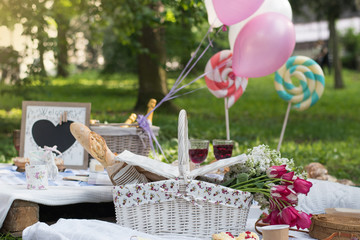 Picnic decorations, cannotier, flowers, fruits. Picnic at the park on the grass: tablecloth,...