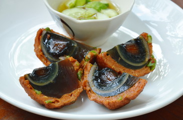 fried preserved egg wrapped fish patty dipping sweet sauce