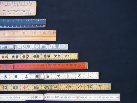 Rulers and scales in metric and inches represent measurement, accuracy and results with copy space. Graphic indicates large numbers at base declining to smaller at top.