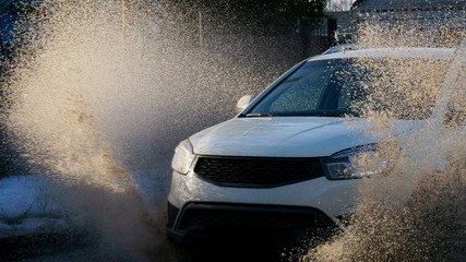 The car is driving at high speed in a puddle
