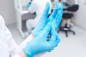 Fertility lab with technician holding tools for fertilizing human eggs showing petri dish