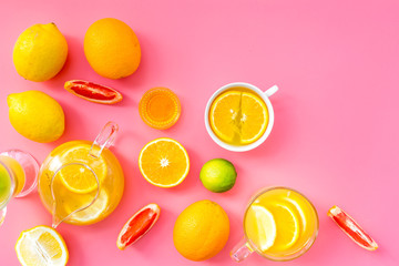 Naklejka premium Brew fruit tea. Teacup and teapot near orange, lime, lemon, grapefruit on pink background top view space for text