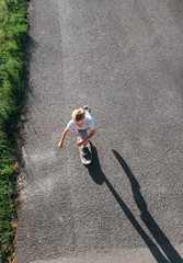 Boy skates on skateboard on asphalt road
