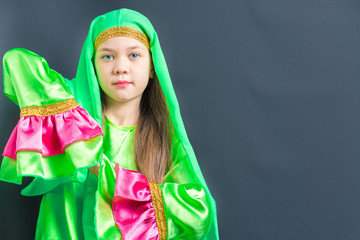 Beautiful girl in green hijab for oriental dance holds hands together