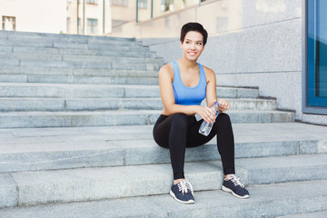 Fototapeta premium Woman runner is having break, drinking water