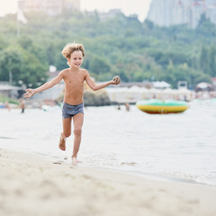 Cheerful happy kid having fun during sea vacation, image with square aspect ratio