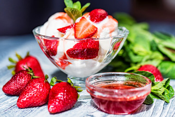 Strawberry ice cream with mint in bowl and jam