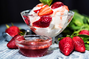 Strawberry ice cream with mint in bowl and jam