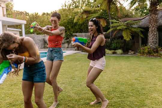 Friends having fun playing with water guns