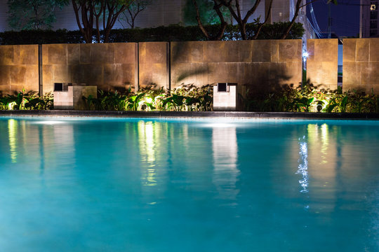 Lush pool lighting in backyard for luxury swimming pool design created by great lighting professionals.