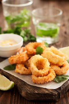 Fried calamari rings on wooden cutting board