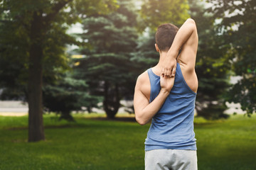Man training yoga in cow head pose outdoors
