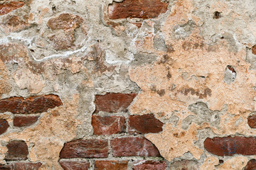 cracked plaster on the brick wall
