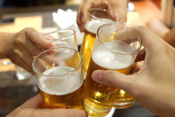 People having celebration by toasting beer in the glass