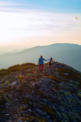 Mom and teenage girl are walking along a stony ridge