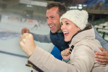 Couple cheering on their ice hockey team