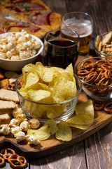assortment of snacks for beer, fast food on wooden table, vertical