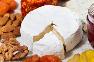 assortment of snacks with cheeses, fruits and nuts, closeup