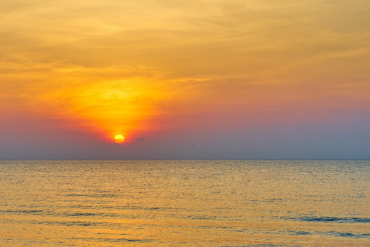 Sun set on water sea with waves and orange color sky background