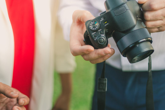 Business man settings a camera for friend to take a photo