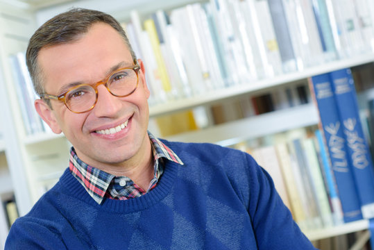 Man in library wearing eyeglasses